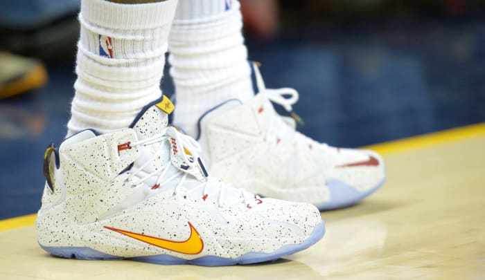 View of white and gold Nike LeBron shoes.
